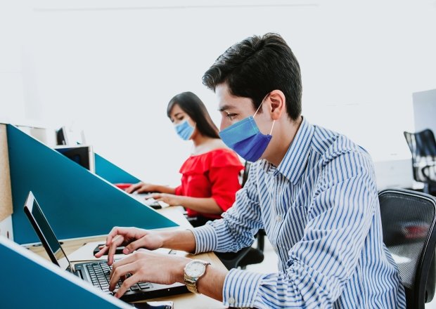 Workers with face masks at computers.
