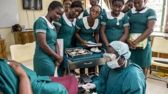 Midwife Charity Mote advises students through a simulated birth process in Ghana.