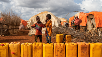 Children standing in line to fill water and yellow drums in Baidoa, Somalia, 2019. Shutterstock