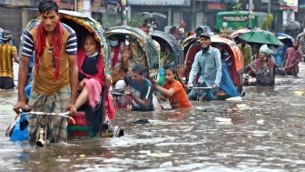 Vehicles try to drive through a flooded street in Dhaka, Bangladesh.