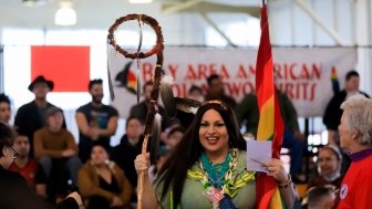 Native American Indian holds a traditional Grand Entry eagle staff 