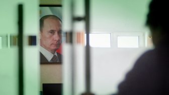 Image of Vladimir Putin behind closing door