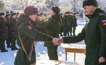 young soldier shakes hand of military recruitment officer