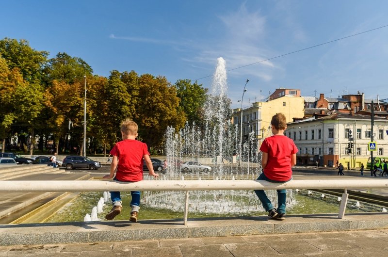  boys sit and look at the fountain in the center of Kharkiv, Ukraine