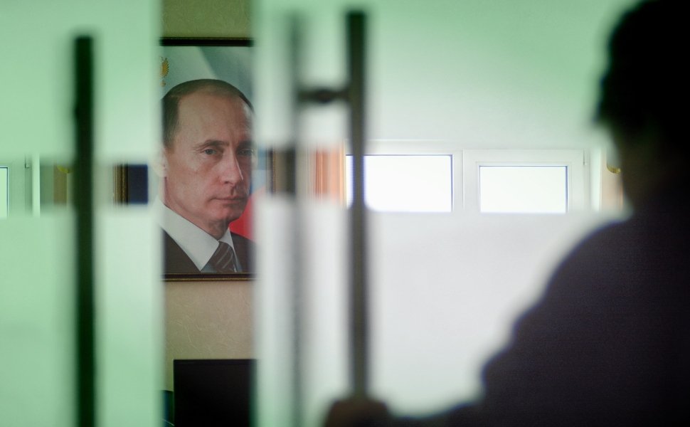 Image of Vladimir Putin behind closing door