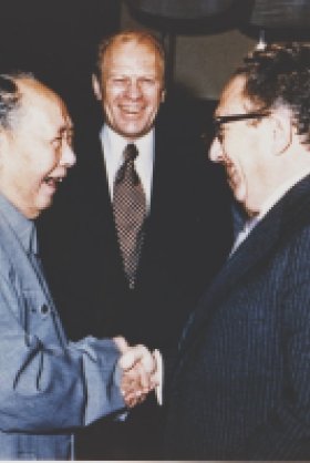 President Ford and daughter Susan watch as Secretary of State Henry Kissinger shakes hands with Mao Tse-Tung; Chairman of Chinese Communist Party, during a visit to the Chairman’s residence.
