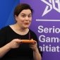 Elizabeth Newbury blowing out a candle at the Serious Games Initiative's 20th Anniversary 