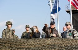 Vice President Biden stands with a group of soldiers at a barricade.