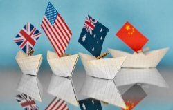 Four paper boats with national flags, from L to R, the UK, the US, Australia, and China.